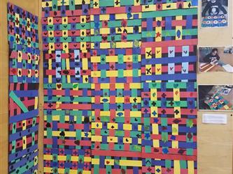 Student art of a yellow, green, red, blue and light blue interweaved panel